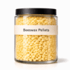 Beeswax Pellets by Organicsbyjumira — white smooth cosmetic wax pellets in a clear laboratory jar.