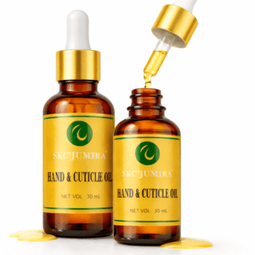 "Two SKC’Jumira Hand & Cuticle Oil bottles with gold droppers, one open with oil dripping, shown on a white background."