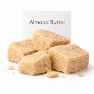 “Almond Butter by Organicsbyjumira — creamy pale-beige cosmetic butter with a smooth, slightly waxy texture in a wide-mouth clear jar for skincare formulation.”