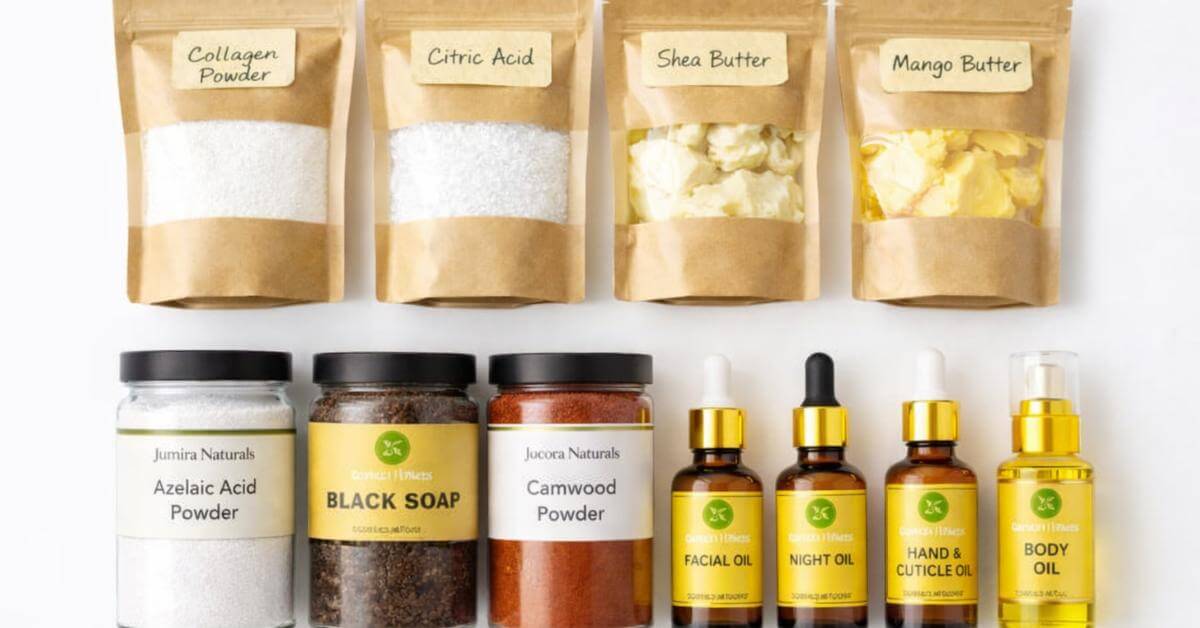 Cosmetic raw ingredients including butters powders and oils arranged on green linen — Jumira Naturals Nigeria